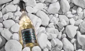 Un vino pugliese bianco, Bellagriffi Moscatiello Selvatico, riposa tra ciottoli bianchi.
