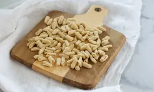 Un mucchio di cavatelli pugliesi freschi su un tagliere di legno, pronti per essere cucinati.